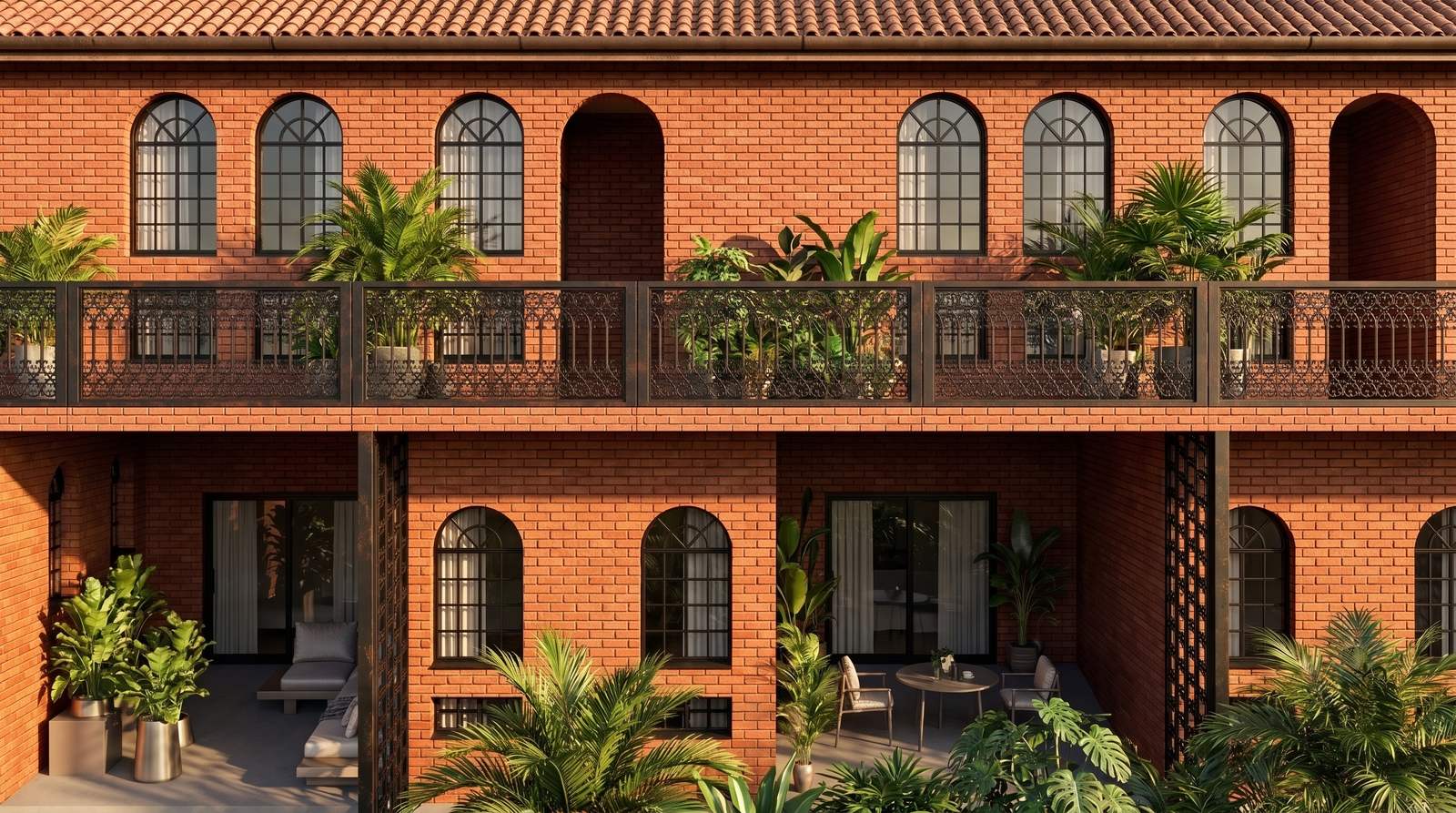 Clay-brick facade of a two-storey boutique hotel in Kitisuru with arched black-framed windows, an iron balcony and tropical planting.